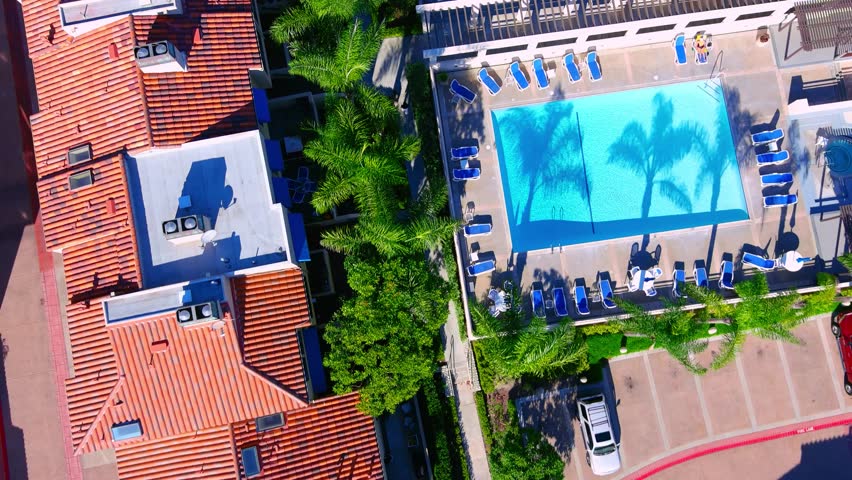 Aerial footage of luxury homes with tennis courts and swimming pools, sandy beach with vast blue ocean water, the blue waters of Huntington Harbour with boats and yachts in Huntington Beach California