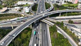 Aerial drone time lapse video of multilevel bridge highway road interchange passing near urban residential area during rush hour