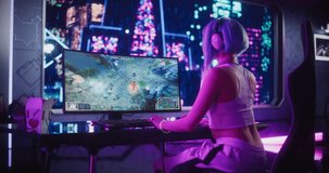 Stylish Female Gamer Playing Fantasy Strategy Video Game with Modern Graphics on Her Computer. Futuristic Cyberpunk Gaming Neon Room with Cosplay Gamer Girl in Headphones. Footage from the Back