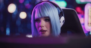 Close Up Portrait of a Stylish Streamer and Video Gamer with Blue Hair Chats with Internet Fans on Computer in Futuristic Cyber Technology Room. Footage for Social Media, Streaming, and Gaming Content