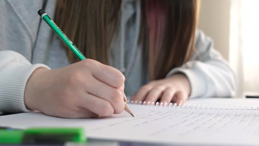 Taking notes in the notebook with colored pencils, writing with pencil and highlighter, summarizing with colored pencils