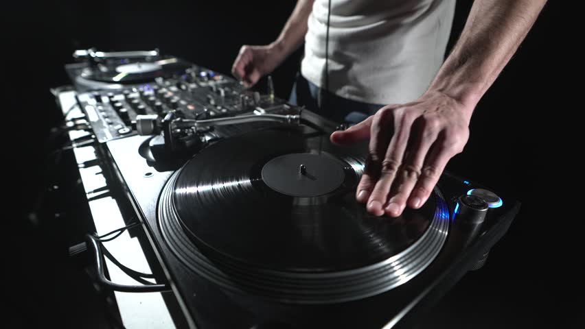Hip hop DJ scratching vinyl disc on a turntable player. Professional disc jockey playing music on a rap concert Royalty-Free Stock Footage #1102891915