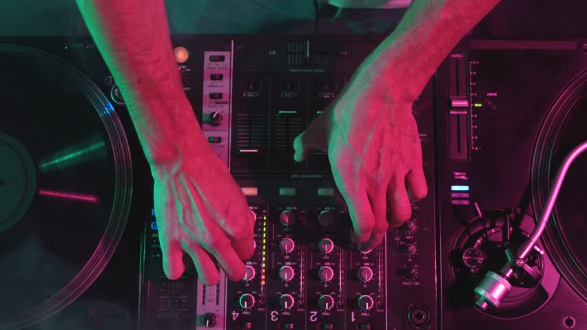 Hands of a DJ playing music with sound mixer and vinyl records.  Royalty-Free Stock Footage #1102891917