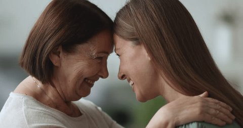 Close up portrait two generation women, older mother, young adult daughter look at each other with love and tenderness, laugh, feel happy, enjoy good family relationship, demonstrating support, care : vidéo de stock