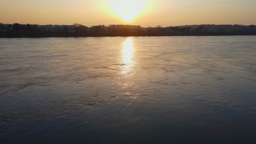 Aerial view flying low over water at amazing sunset over river Vistula in Poland. Beautiful landscape in springtime. Concept of nature ecology protection