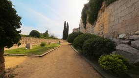 A view of Archaeological Walk, with monumental roman walls, in Tarragona, Spain. High quality 4k footage