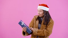 4K, woman in long-sleeved shirt with fluffy because cold on christmas night, hugged received gift box smiles, looks happily on night christmas, Isolated indoor studio on pink background. - Powered by Shutterstock - Get 15% off with code: PIKWIZARD15