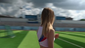 Portrait of a young caucasian woman in sportswear at the stadium outdoors. Video 360 degrees.