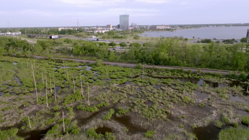 Wide shot of Lake Charles, Louisiana skyline with bayou in the foreground.