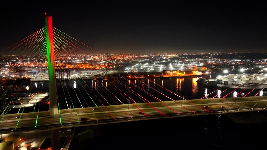 Night aerial of Gerald Desmond Bridge over the city lights of Long Beach, CA