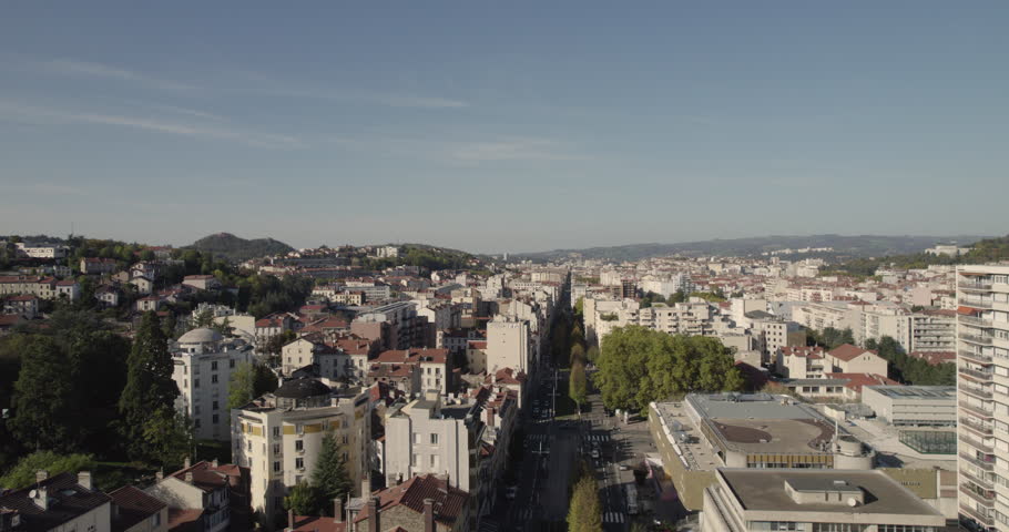 Aerial view in city center of Saint-Etienne in France during sunset with blue sky and mountains on the horizon. Royalty-Free Stock Footage #1102909649