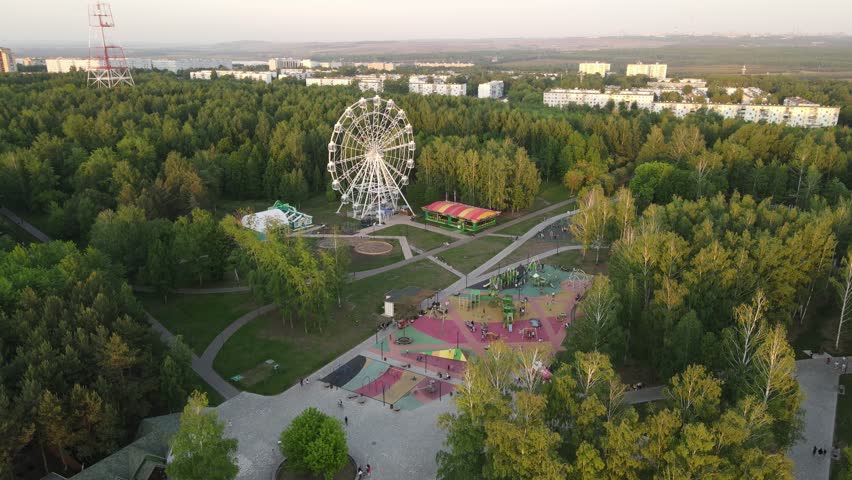 Central park of the city of Nizhnekask. Aerial view, summer, sun, greenery, ferris wheel, amusement park