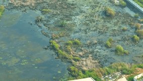 From an aerial view, industrial wastewater can be seen as dark and discolored water that may be mixed with sediment, foam, and debris. The wastewater can be discharged into rivers, lakes. Drone
