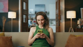 Smiling woman texting telephone at living room zoom on. Positive happy woman chatting mobile phone social media at home closeup. Chuckling girl face typing cellphone screen communicating at couch - Powered by Shutterstock - Get 15% off with code: PIKWIZARD15