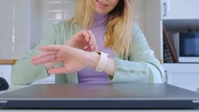 Adult white woman browsing notifications on a modern smart watch. Blonde female person using smart wrist watches 