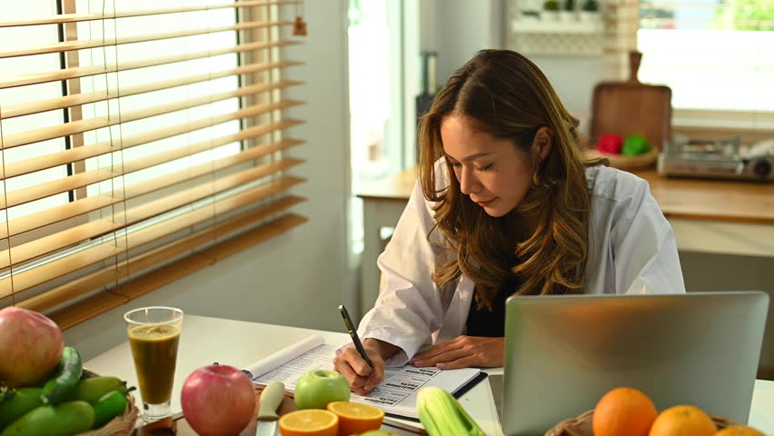 Smiling young female dietitian working on diet plan at office. Right nutrition, wellness and healthy lifestyle concept