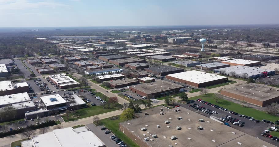 Aerial view of an office park with low-rise buildings near a highway in a suburban setting.