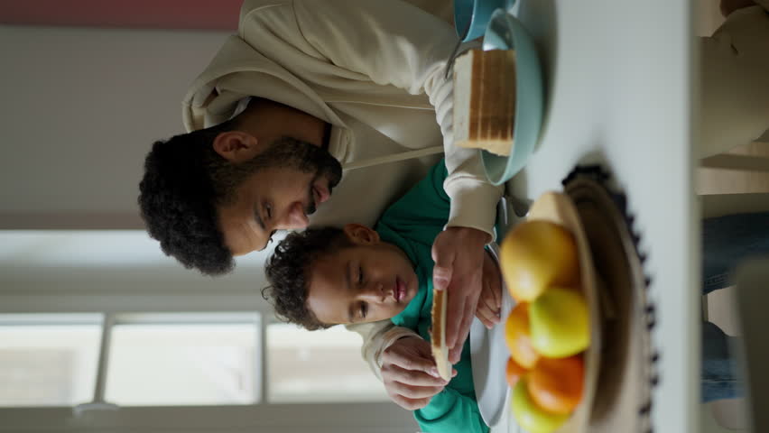 Father and son having breakfast together. Vertical view. | Shutterstock HD Video #1102923617