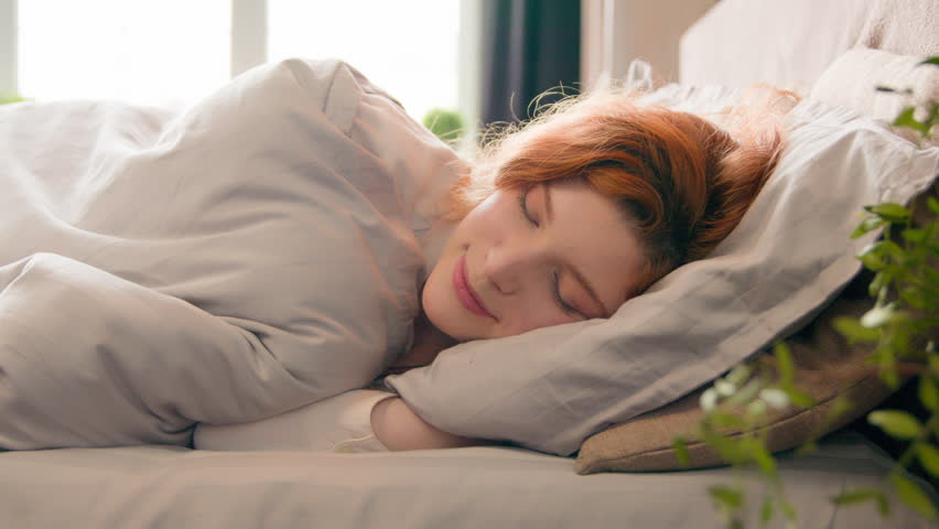 Caucasian happy woman sleeping in comfortable cozy bed at home girl lady asleep lying on soft pillow white linen orthopedic mattress resting relaxing napping healthy sleep nap in morning stress relief | Shutterstock HD Video #1102935051