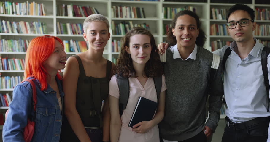 Happy multi-ethnic students pose in university library, looking at camera, showing thumbs up like gestures, smile, laughing, ready for exams, engaged in teamwork, enjoy friendship. Excellent studies Royalty-Free Stock Footage #1102944011
