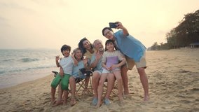 4K Group of Asian Multi-Generation family enjoy and fun outdoor lifestyle travel ocean on summer beach holiday vacation. Happy family using mobile phone taking selfie together at the sea at sunset. - Powered by Shutterstock - Get 15% off with code: PIKWIZARD15