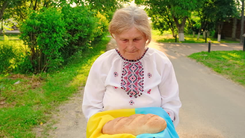 Grandmother with Ukrainian bread in her hands. Selective focus. Food.