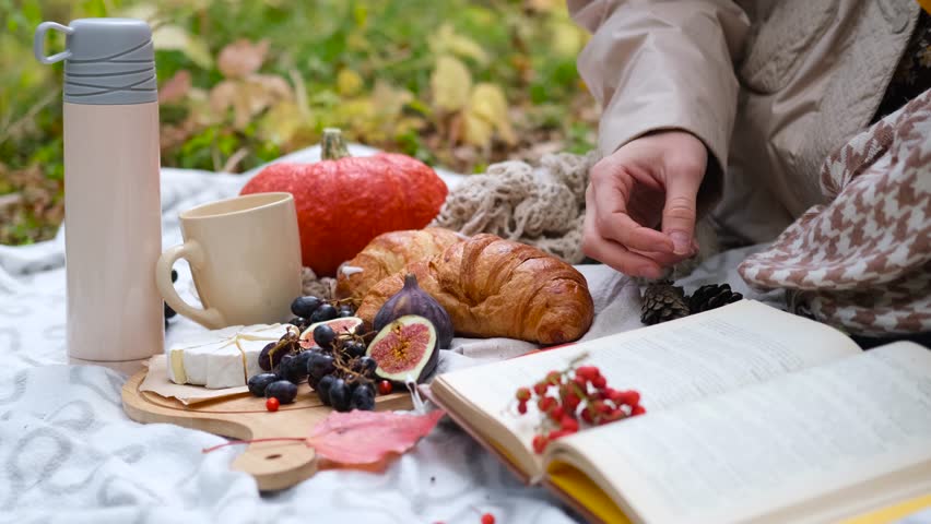 Young mother with her little daughter in the autumn park on a picnic. Close-up