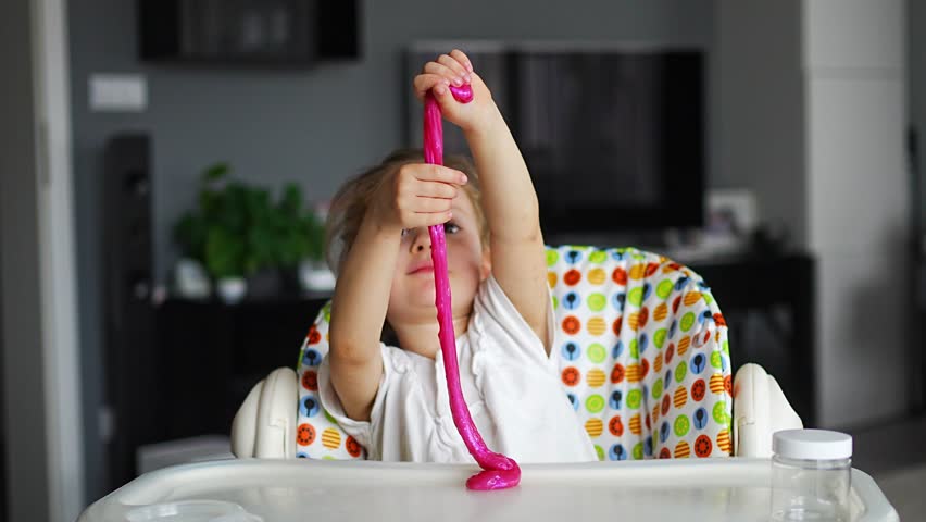 Little girl is playing with a homemade pink slime. Kids hands playing slime toy in home. High quality 4k footage