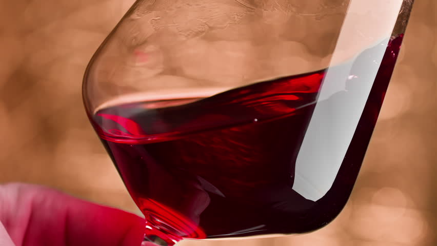 Male hand swirling red wine in wine glass. Waving red wine in glass. Wine tasting and winemaking concept. Royalty-Free Stock Footage #1102963487