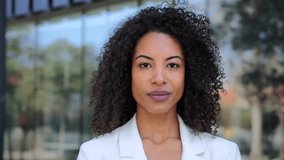 Serious african american businesswoman looking pensive at camera with proud attitude wearing a executive suit Close up portrait of hispanic corporate female worker with curly hair standing at worplace - Powered by Shutterstock - Get 15% off with code: PIKWIZARD15