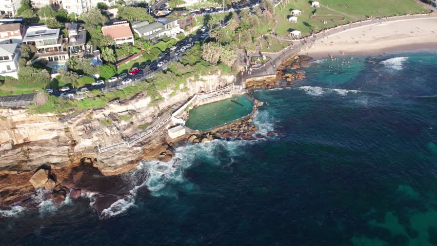 Stationary Aerial View of Bronte Beach Ocean Pool. People Swimming in the Pool on a Sunny Day.