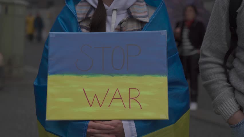 Germany, Munich. Demonstration of Ukrainians against Russia war in Ukraine at Odeonsplatz. Demonstrators contrary invasion of russia into Ukraine. Protest and meeting against war  Royalty-Free Stock Footage #1102968179