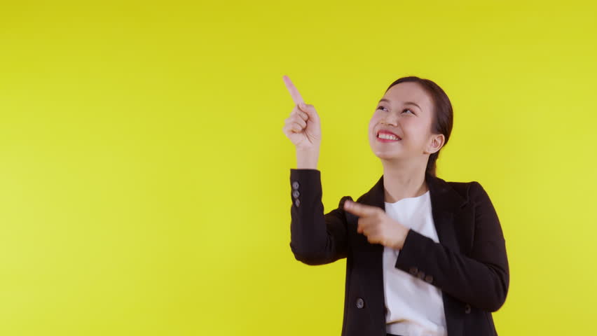 Portrait young asian business woman pointing and presenting isolated on yellow background, advertising and marketing, executive and manager, businesswoman confident showing something with expression. Royalty-Free Stock Footage #1102969111