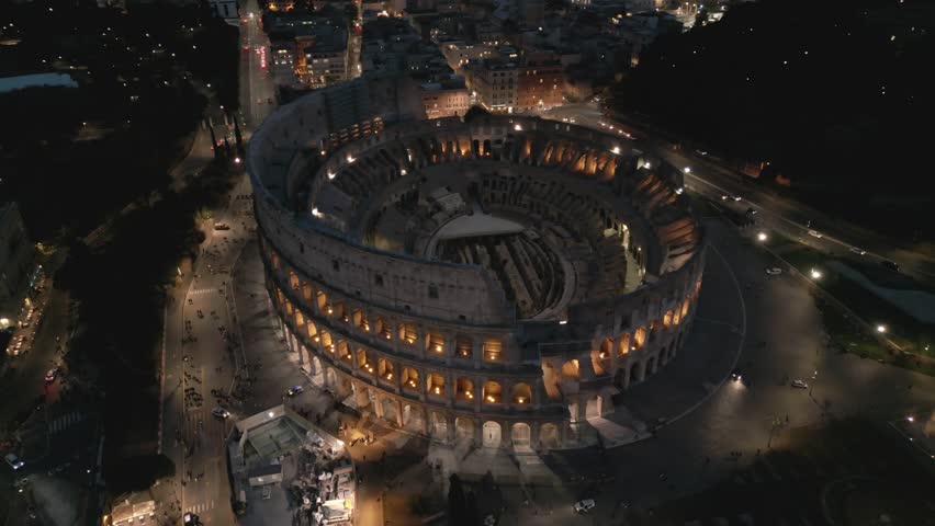 Aerial drone view of the Colosseum at night, Rome, Italy, Europe. Ancient Roman ruin is the top landmark of Rome. Night view. Royalty-Free Stock Footage #1102969865