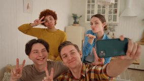 Best friends take selfie photo together on smartphone with hands victory signs. Diversity people smile, relax, hang together, give air kiss to smartphone camera. Friendship, spend time, guy and girls. - Powered by Shutterstock - Get 15% off with code: PIKWIZARD15