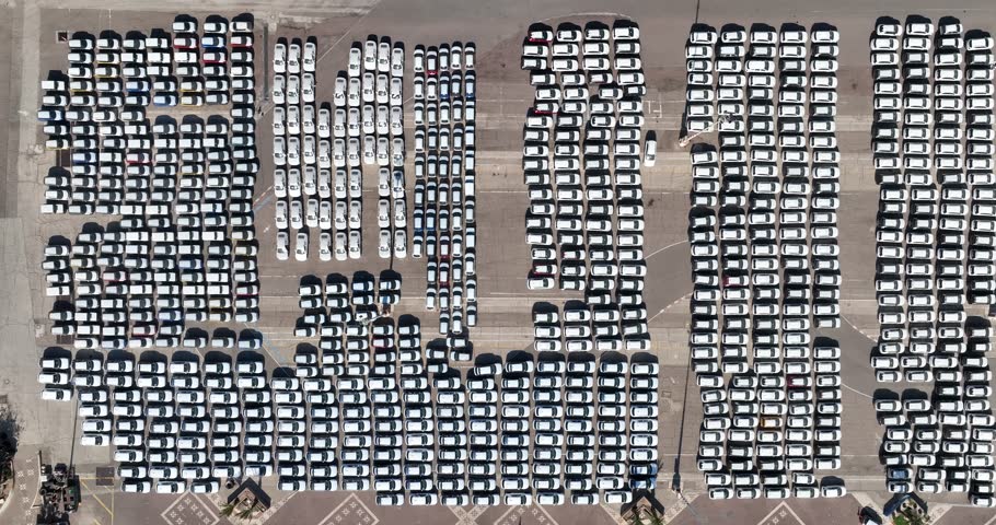 Aerial footage of Eilat sea port in the red sea. Cargo ships anchor in the port and Thousands of vehicles park in and around the port.