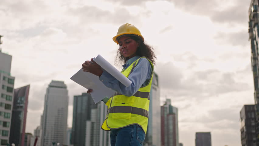 Worker woman or Industry maintenance engineer female dark skin wearing uniform and safety helmet under inspection and checking process on construction site.Industry,civil Engineer,construction concept Royalty-Free Stock Footage #1102972339