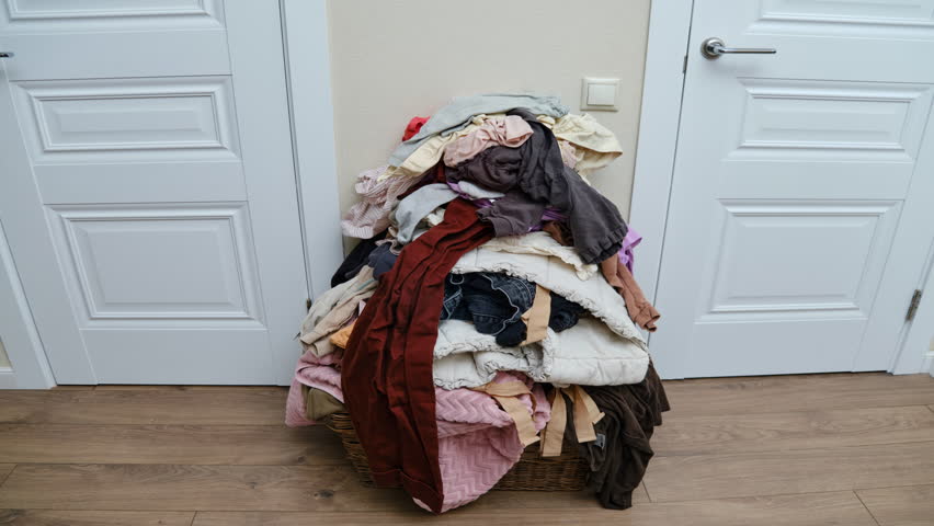 Sorting clothes after washing, time lapse. Filling the basket with adult and baby clothing, stop motion | Shutterstock HD Video #1102972879