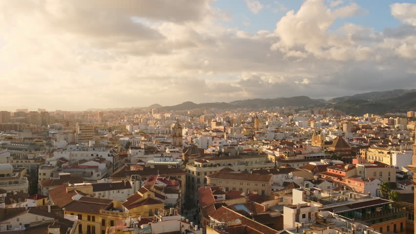 Panoramic view of Malaga city, Spain. Malaga cityscape with beautiful Cathedral of the incarnation at sunset. Panning shot of old town, Cathedral and skyline of the city. Slow panning
