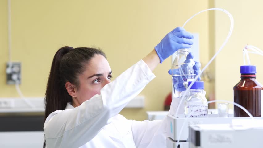 Young scientist or medical technician developing research new pharmacy medicine in glass flask in a clinical laboratory, concept of pharmaceutical studies and researches