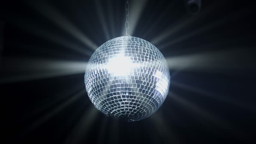 Disco Ball with Reflected Moving Rays Rotating. Mirror disco ball in white light. Isolated disco ball on black background. Close-up. Mirror ball spinning indoors. Performance. The reflection of lights Royalty-Free Stock Footage #1102987959