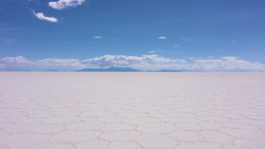Uyuni Salt Flats on Sunny Day. Salar De Uyuni. Aerial View. Altiplano, Bolivia. Dry Season. Hexagonal Salt Formations. Drone Flies Forward at Low Level. Wide Shot Royalty-Free Stock Footage #1102990991