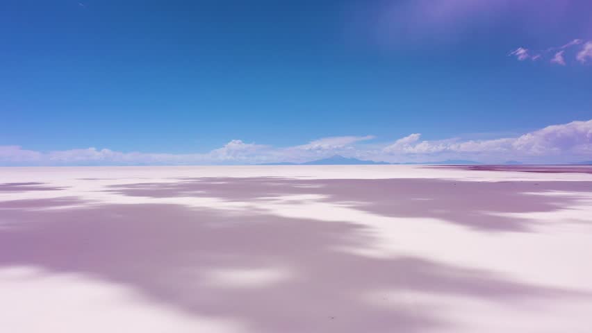 Uyuni Salt Flats. Salar De Uyuni. Aerial View. Altiplano, Bolivia. Dry Season. Clouds Shadows. Drone Flies Forward. Wide Shot