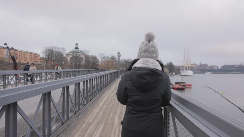 Tranquility View Of A Traveler Woman Strolling At Skeppsholm Bridge In Stockholm, Sweden. shoulder-level shot