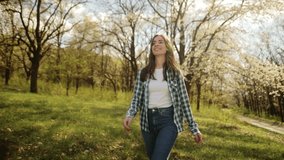 portrait of charming smiling young woman in blooming garden, attractive woman walking under fruit blooming tree, enjoying warm sunny day and nature in spring - Powered by Shutterstock - Get 15% off with code: PIKWIZARD15