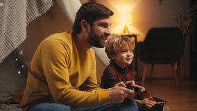 Positive little boy and father playing video game inside blanket fort, family - Powered by Shutterstock - Get 15% off with code: PIKWIZARD15