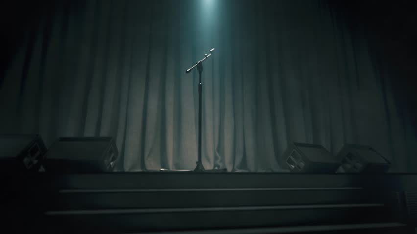 Stand with a microphone on an empty stage. Microphone on empty comedy club stage. Empty scene with microphone Royalty-Free Stock Footage #1103007381