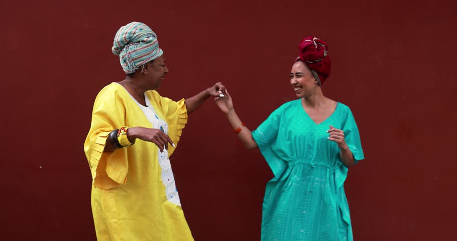 Happy african mother and her daughter wearing ethnic traditional dress while dancing together outdoor  | Shutterstock HD Video #1103007681