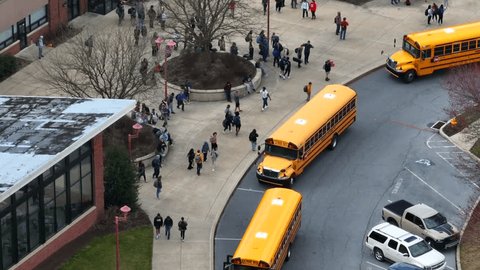 Lititz , PA , United States - 03 28 2023: Students at public school campus buildings as school busses arrive to transport learners. Diversity DEI theme in American education.  编辑库存视频