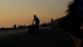 Man riding bike sunset videos, cycling at sunset, outdoor sports activities, black and yellow silhouettes, bike ride and adventure